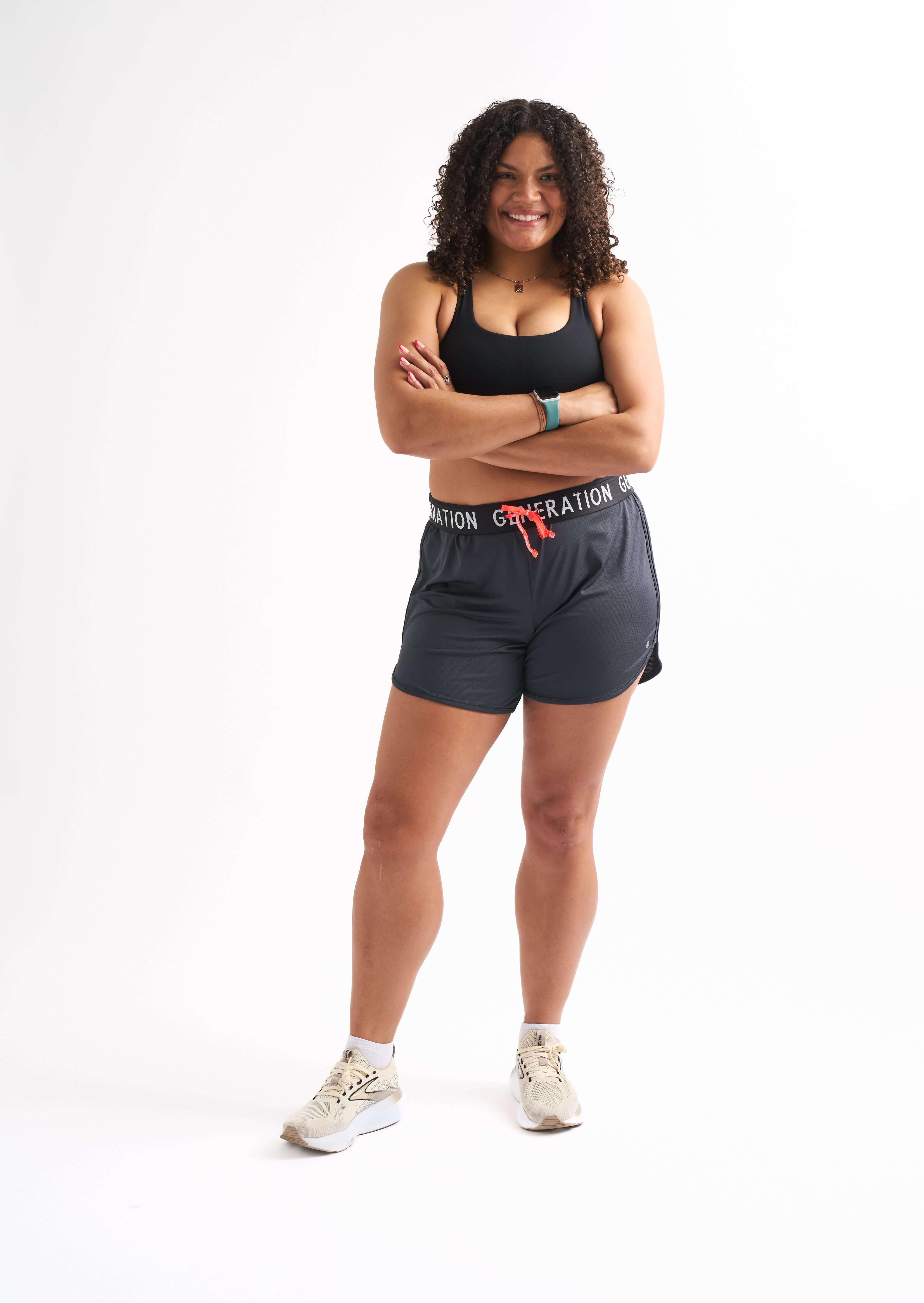 Cheerful woman wearing Locked In drawstring running shorts, showcasing comfort and style for active wear.
