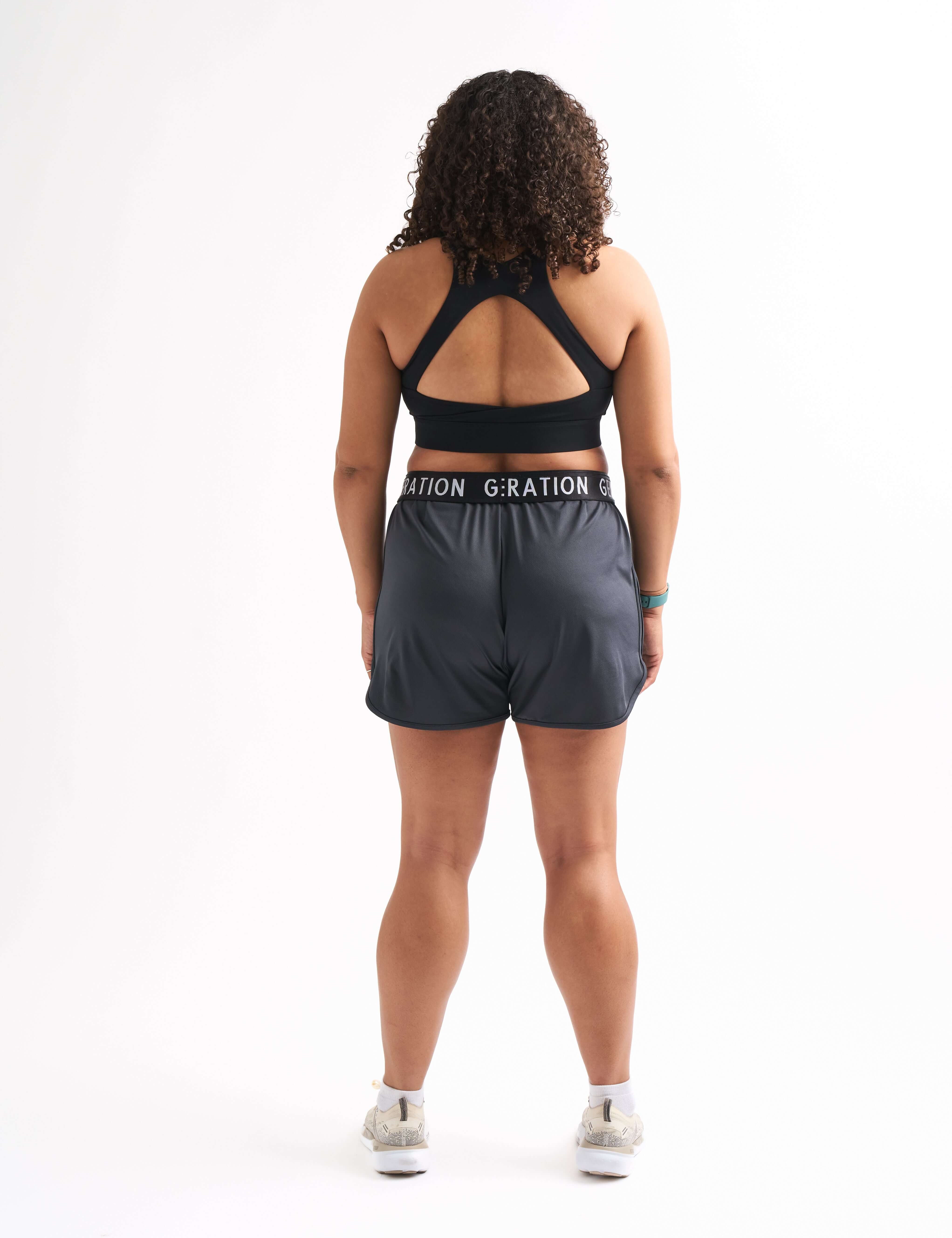 Back view of woman wearing Locked In running shorts, showing foldable waistband and breathable mesh design.