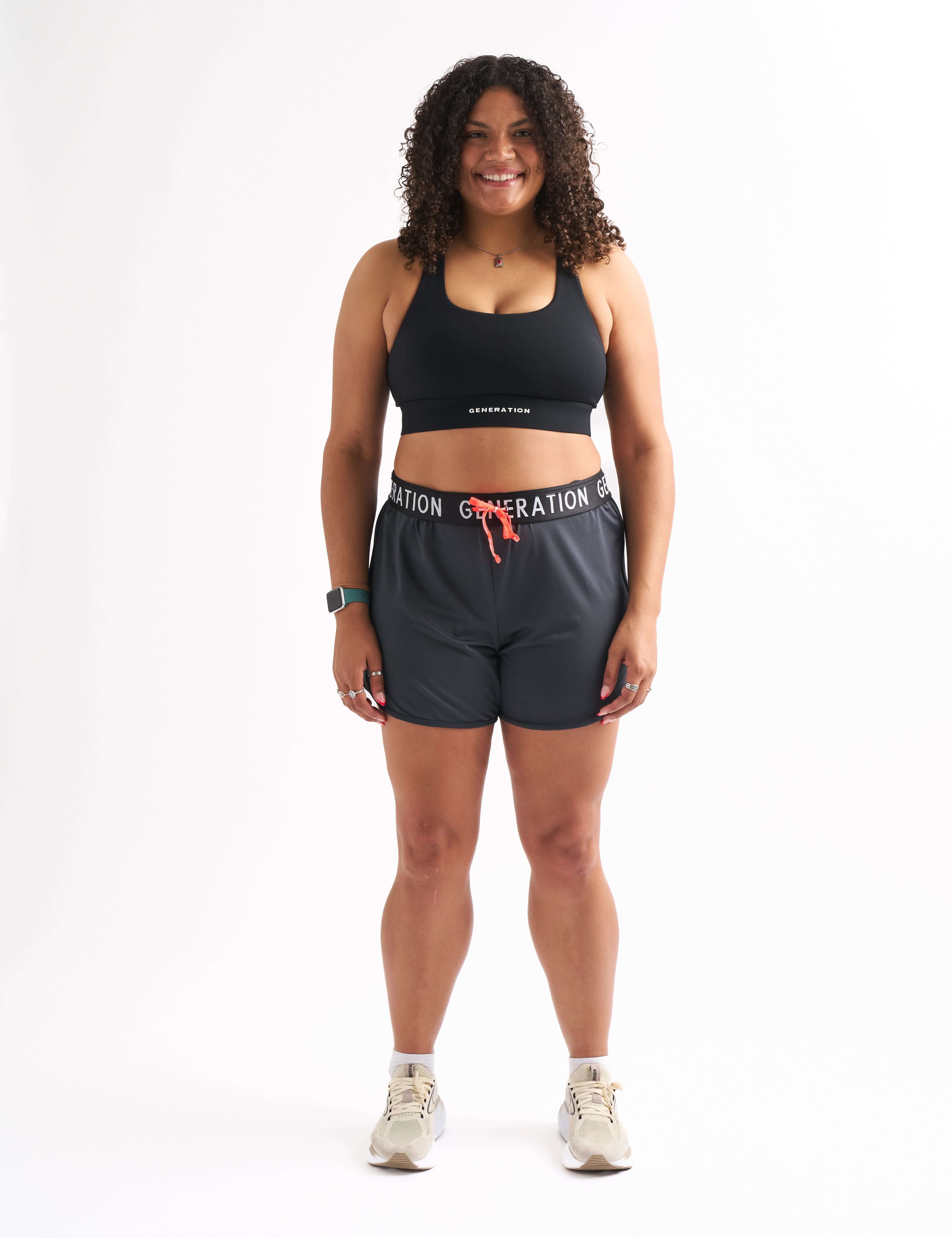 Woman wearing Locked In drawstring running shorts and sports bra with a stylish and comfortable look.