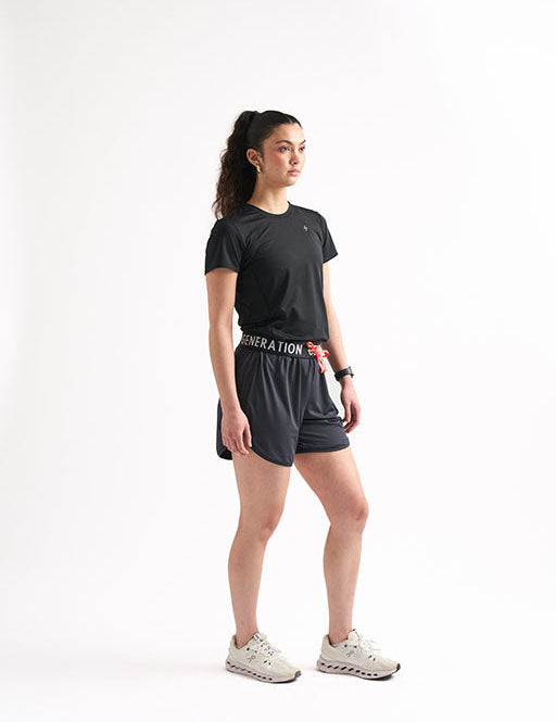 Woman showcasing black drawstring running shorts, featuring a foldable waistband.