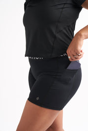 Close-up of the Power Moves Midrise Shorts pocket with a phone tucked inside, highlighting the functional side pocket.