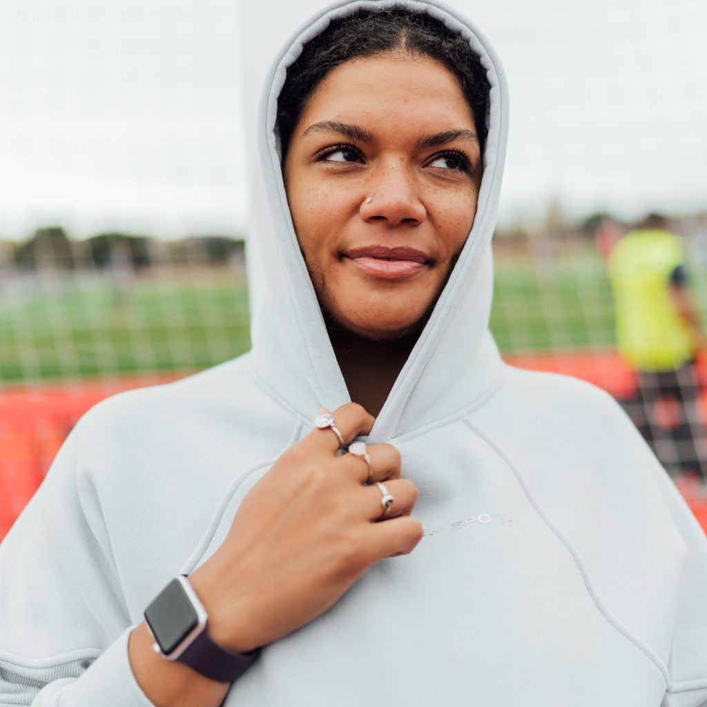 woman in grey hoodie with hood up.