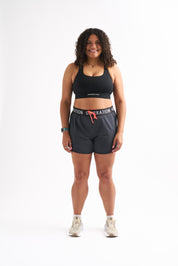 Woman wearing Locked In drawstring running shorts and sports bra with a stylish and comfortable look.