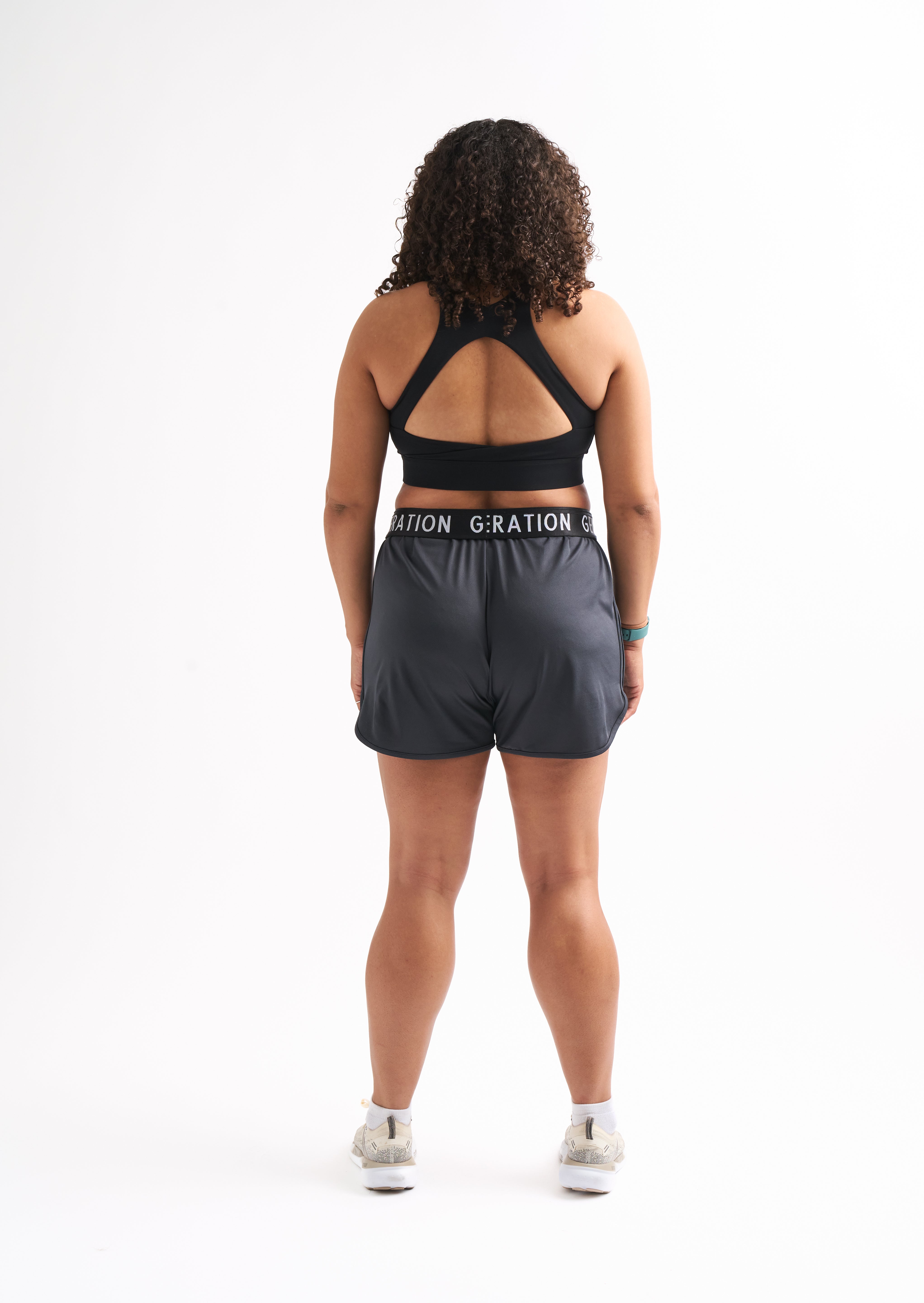 Back view of woman wearing Locked In running shorts, showing foldable waistband and breathable mesh design.