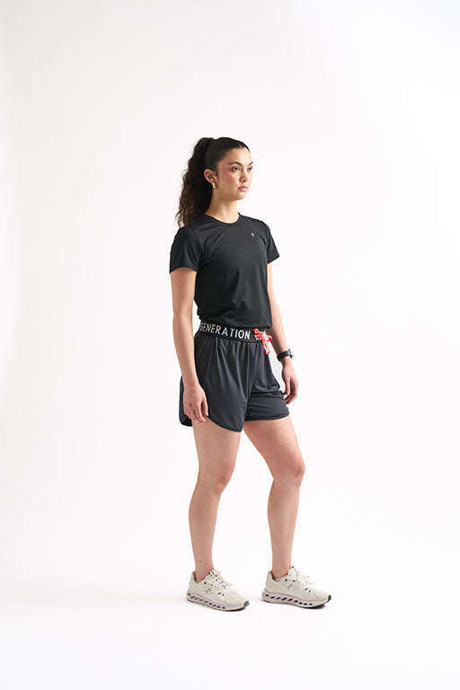 Woman showcasing black drawstring running shorts, featuring a foldable waistband.