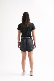 Woman showcasing the back view of black running shorts, perfect for workouts and practice.