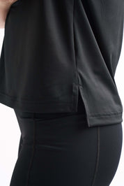 Close-up detail of the side seam on the Flow State top, shown over black leggings.