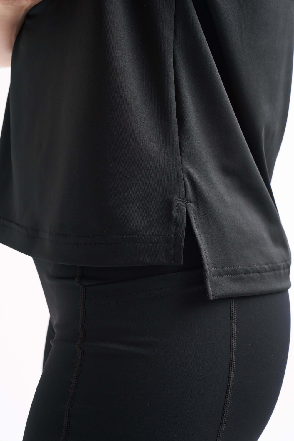 Close-up detail of the side seam on the Flow State top, shown over black leggings.