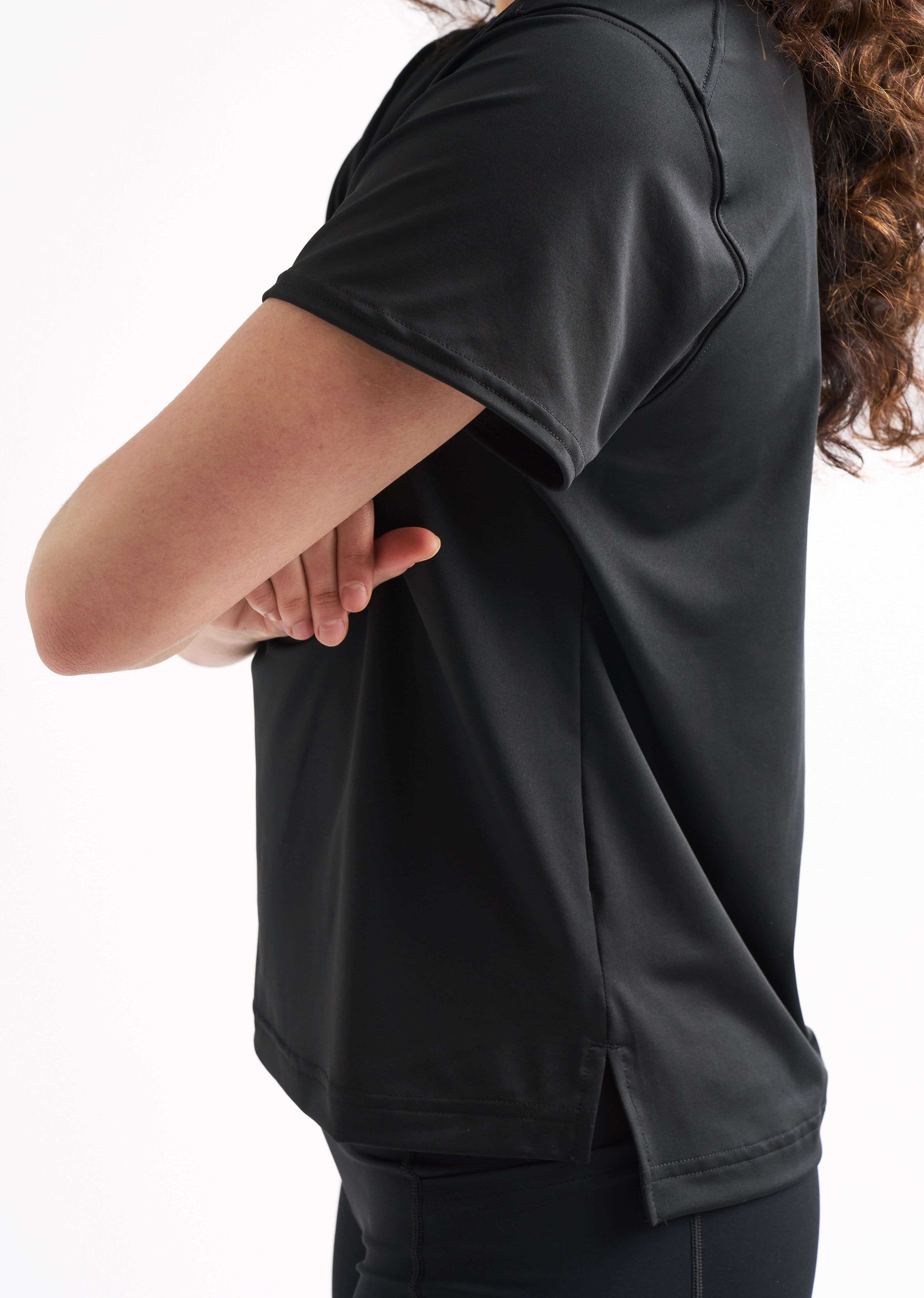 Close-up side view of a woman with arms crossed, highlighting the sleeve and fit of the Flow State top.