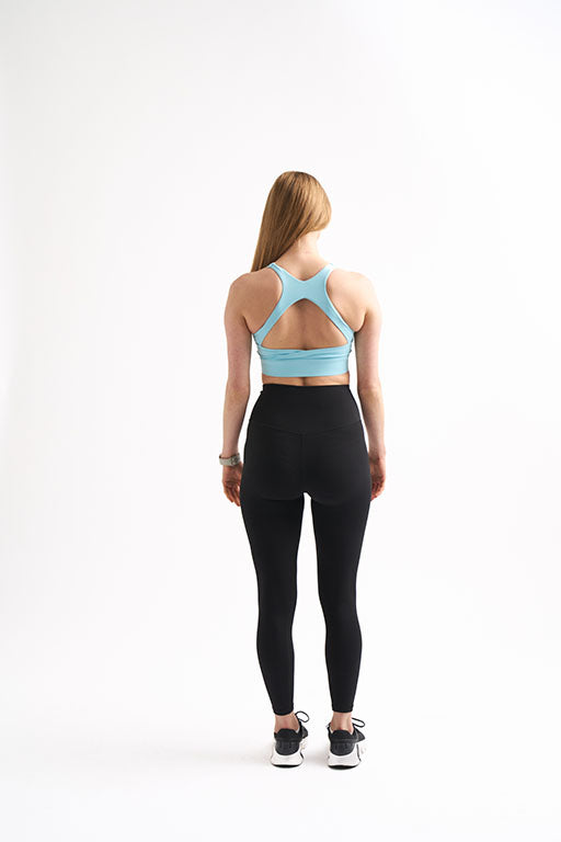 Back view of woman wearing Groundwork Highrise Leggings with relaxed arms.