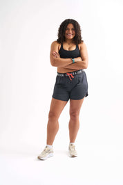Cheerful woman wearing Locked In drawstring running shorts, showcasing comfort and style for active wear.