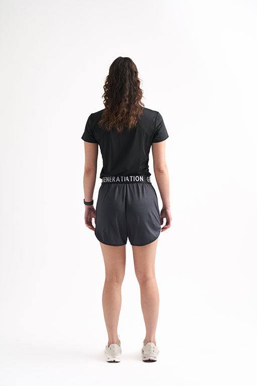 Woman showcasing the back view of black running shorts, perfect for workouts and practice.