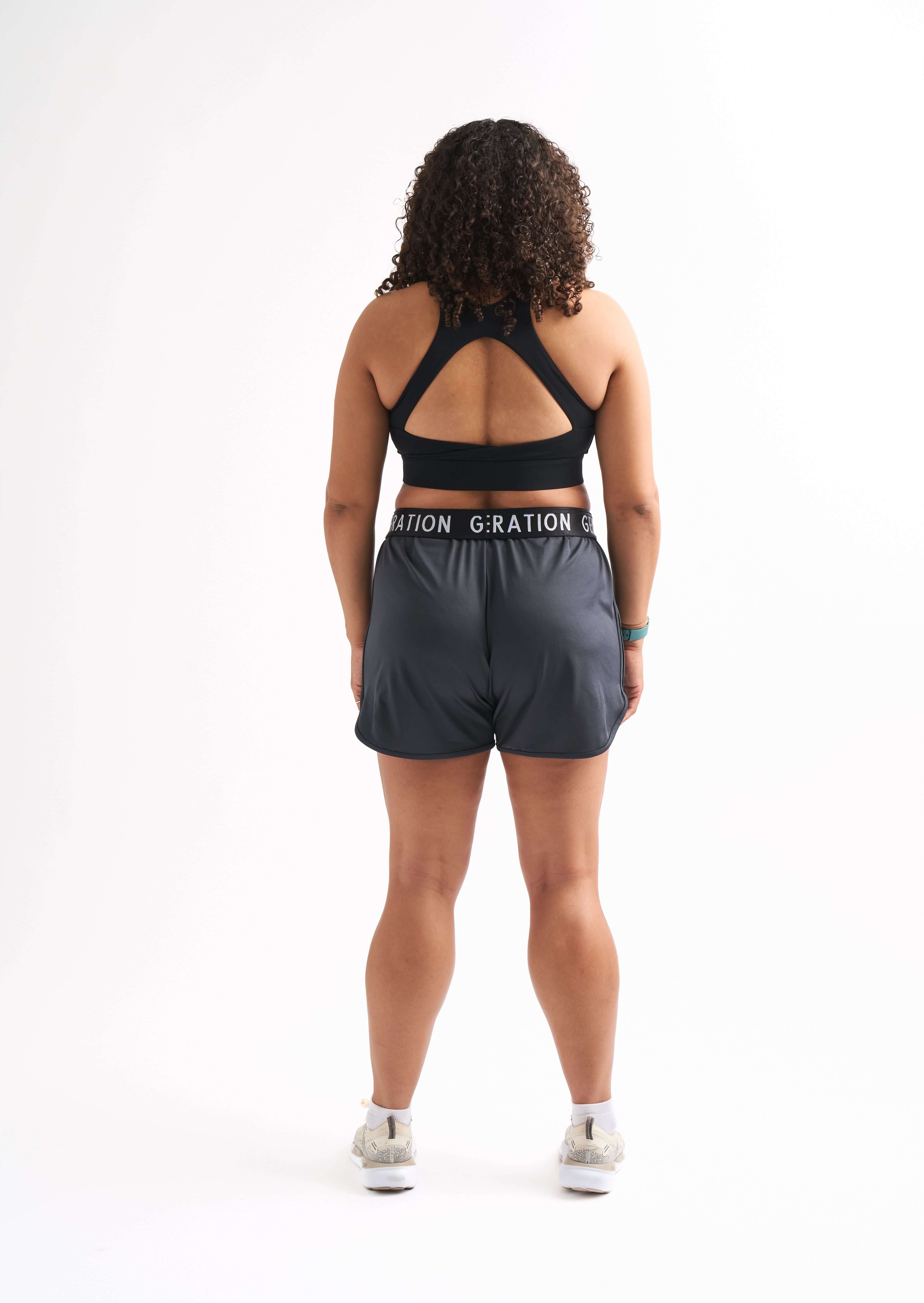 Back view of woman wearing Locked In running shorts, showing foldable waistband and breathable mesh design.