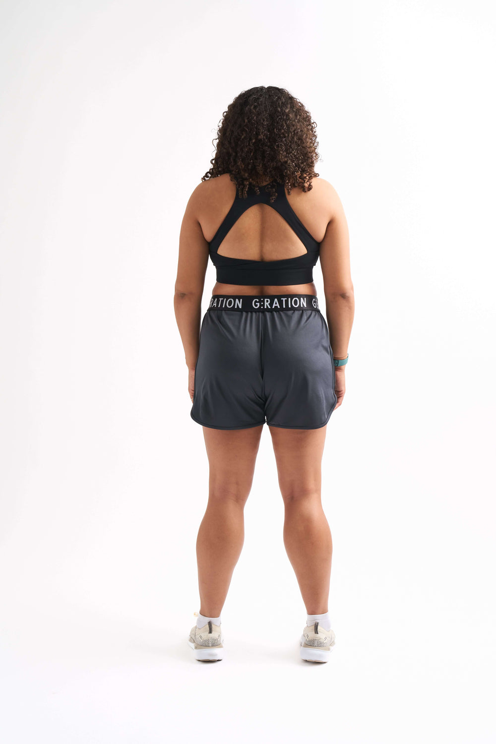 Back view of woman wearing Locked In running shorts, showing foldable waistband and breathable mesh design.