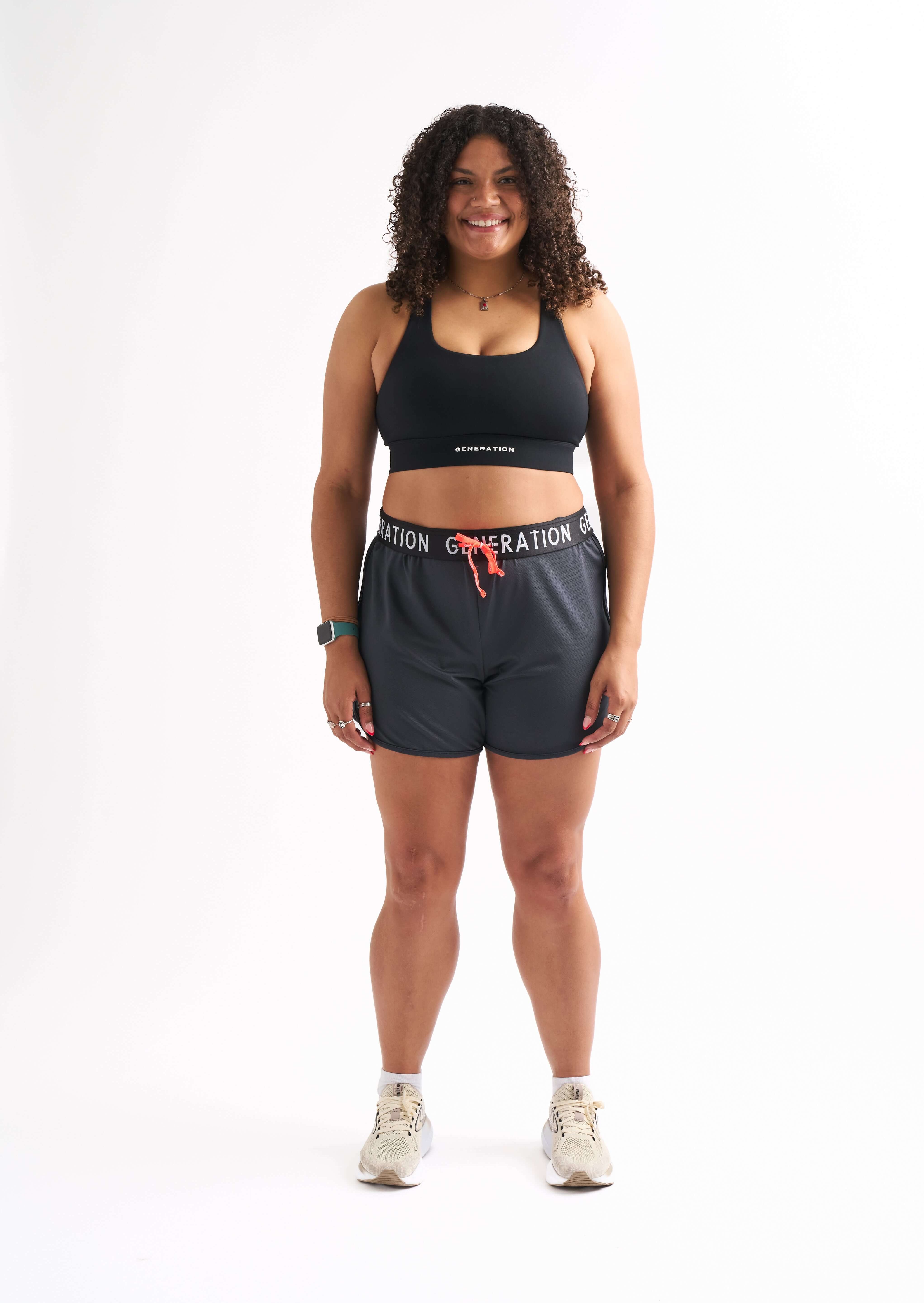 Woman wearing Locked In drawstring running shorts and sports bra with a stylish and comfortable look.