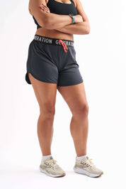 Woman wearing Locked In drawstring running shorts with branded waistband, arms crossed in a neutral standing pose.